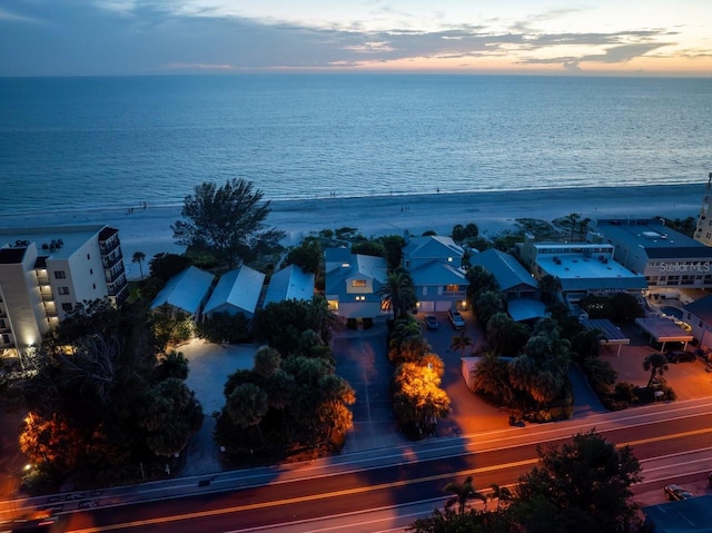 aerial view at dusk featuring a water view