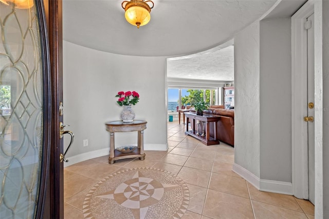 entrance foyer with light tile patterned floors and a textured ceiling