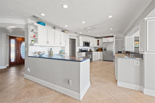 kitchen with white cabinetry, stainless steel appliances, light tile patterned flooring, decorative backsplash, and kitchen peninsula