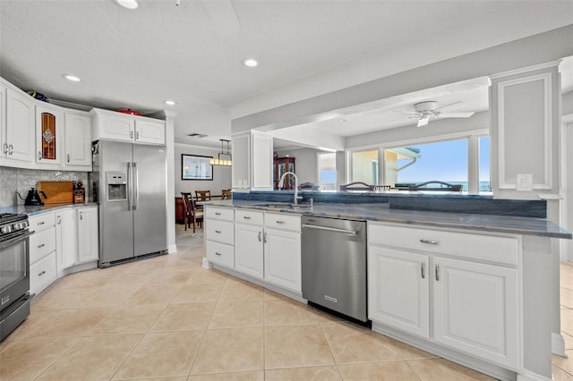 kitchen featuring sink, appliances with stainless steel finishes, backsplash, white cabinets, and light tile patterned flooring