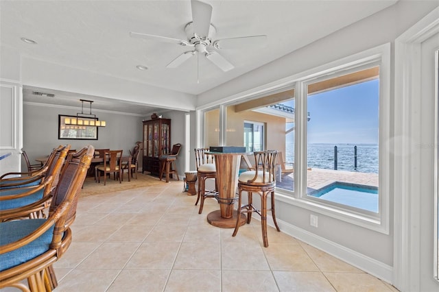 living area featuring a water view, ceiling fan, ornamental molding, and light tile patterned floors