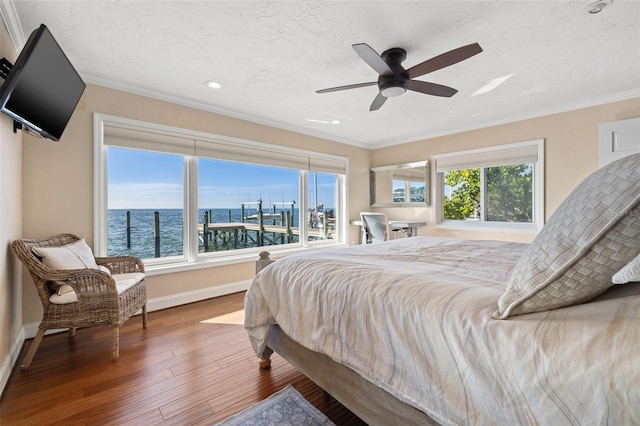 bedroom featuring crown molding, ceiling fan, wood-type flooring, and a textured ceiling