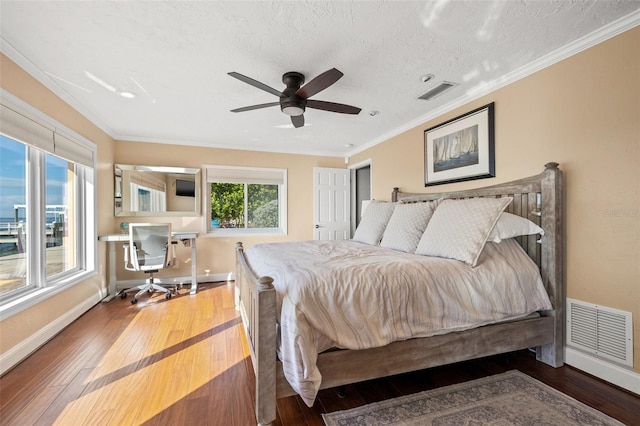 bedroom with ornamental molding, wood-type flooring, and a textured ceiling