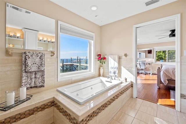 bathroom with ceiling fan, tile patterned floors, and tiled bath