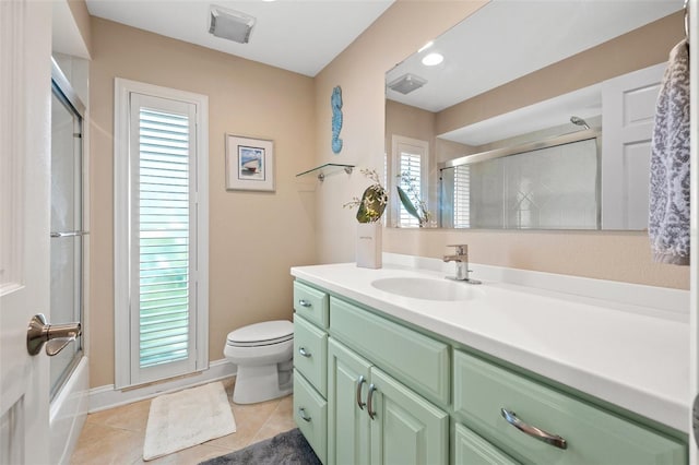 full bathroom with vanity, bath / shower combo with glass door, tile patterned floors, and toilet