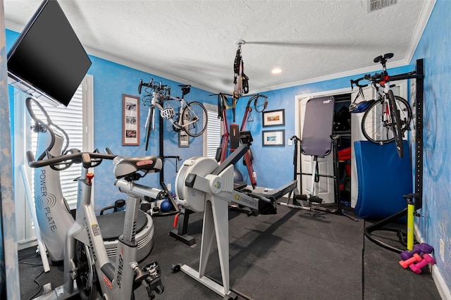 workout room with plenty of natural light, ornamental molding, and a textured ceiling