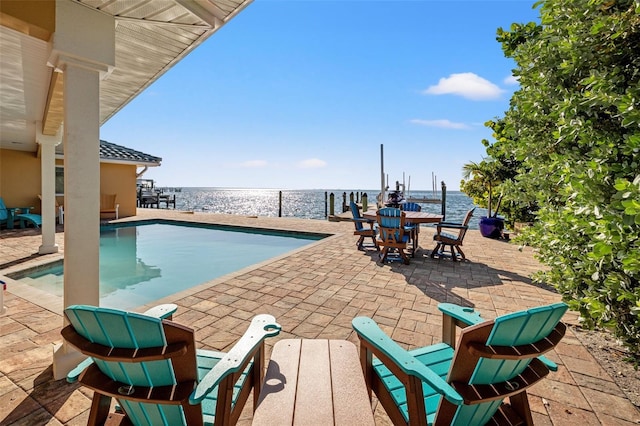 view of pool featuring a patio and a water view