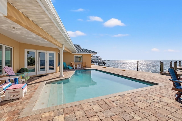 view of swimming pool with a patio area and a water view