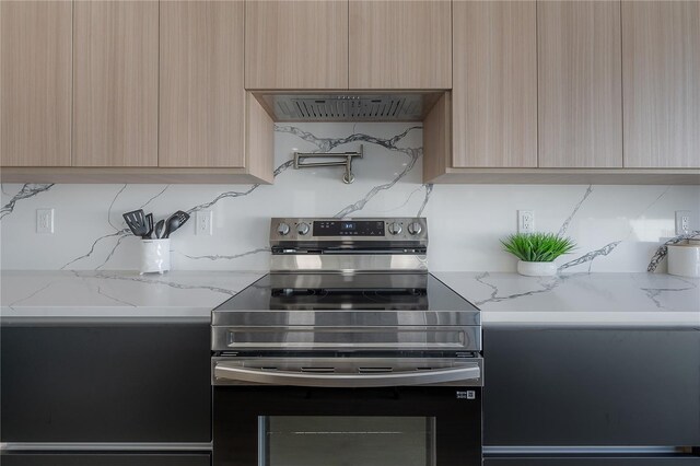 kitchen with range hood, light stone countertops, light brown cabinets, and stainless steel electric range oven