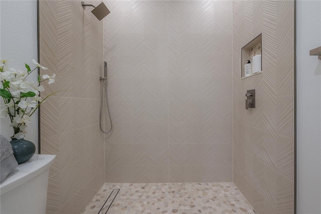 bathroom featuring toilet and tiled shower