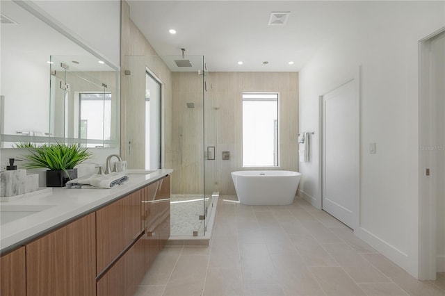 bathroom featuring vanity, tile patterned floors, and plus walk in shower