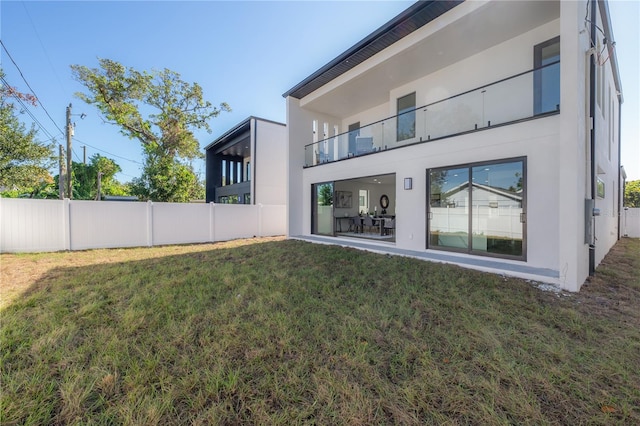 rear view of house featuring a yard