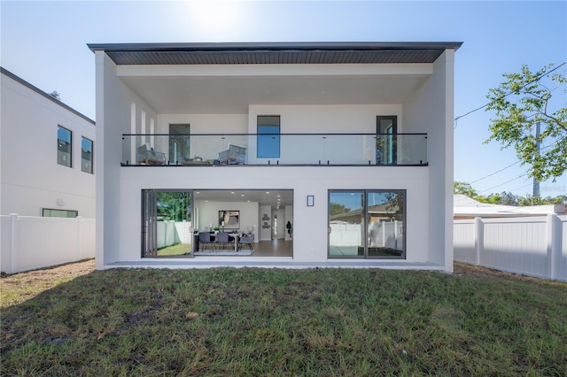 rear view of property with a balcony, a yard, and a patio