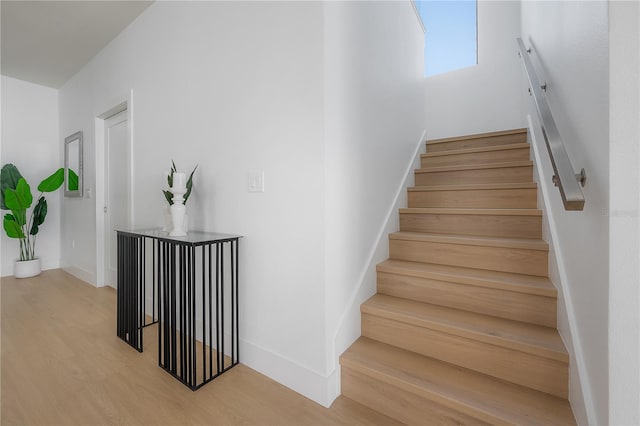 stairway with baseboards and wood finished floors