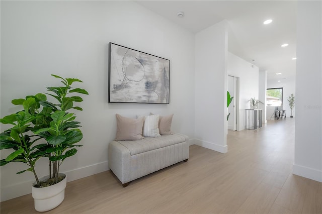 living area featuring baseboards, recessed lighting, and light wood finished floors