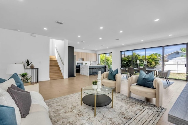 living room featuring a healthy amount of sunlight, light wood-type flooring, and recessed lighting