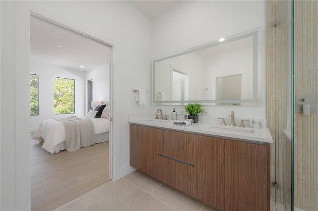 full bathroom featuring tile patterned floors, double vanity, ensuite bathroom, and a sink