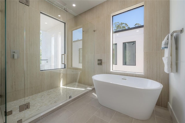full bath with tile walls, a stall shower, tile patterned floors, and a freestanding bath