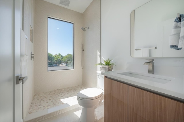 full bathroom with tiled shower, tile patterned flooring, toilet, vanity, and visible vents