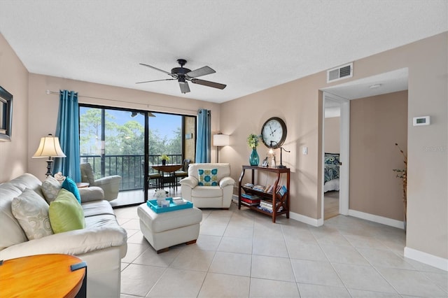 tiled living room with a textured ceiling and ceiling fan