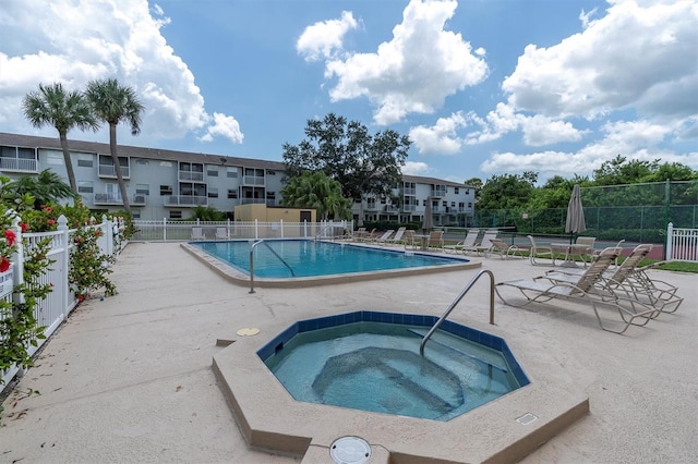 view of swimming pool featuring a community hot tub and a patio