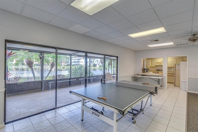 game room with a paneled ceiling and light tile patterned flooring