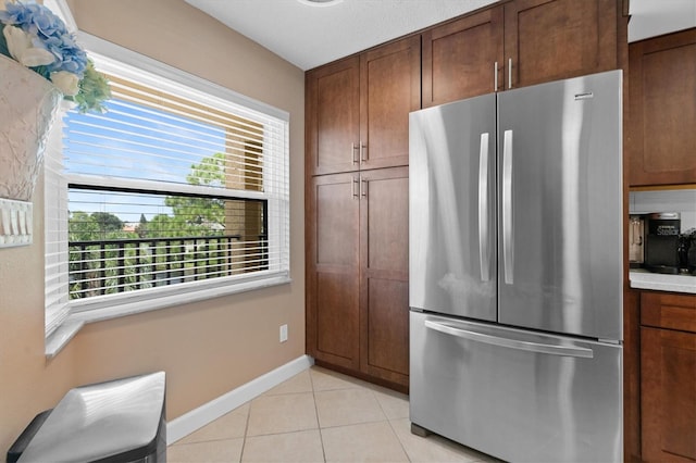 kitchen featuring stainless steel fridge and light tile patterned flooring