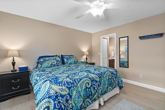 bedroom with ceiling fan, light wood-type flooring, ensuite bathroom, and a textured ceiling