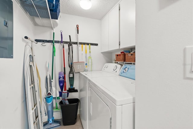 laundry room featuring washing machine and dryer, a textured ceiling, and cabinets