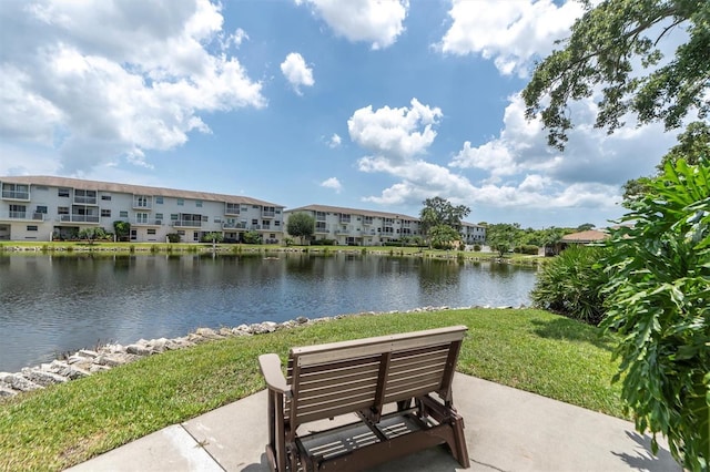 view of property's community with a lawn and a water view