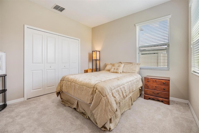 bedroom with light carpet and a closet