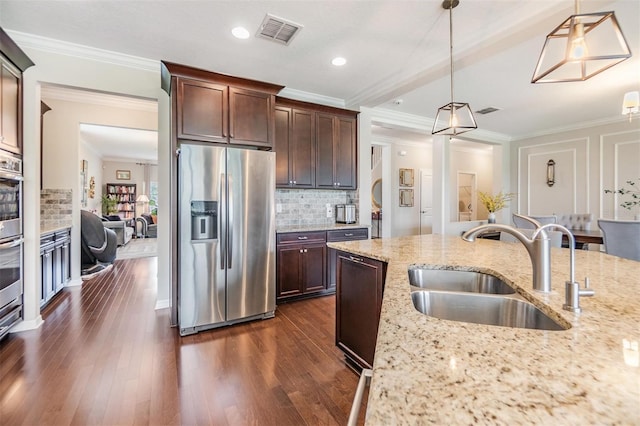 kitchen featuring stainless steel refrigerator with ice dispenser, light stone counters, sink, and hanging light fixtures