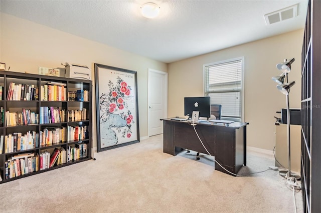 home office featuring light colored carpet and a textured ceiling