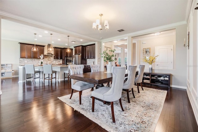 dining room featuring ornamental molding, dark hardwood / wood-style floors, and an inviting chandelier