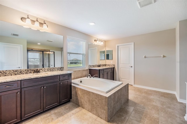 bathroom featuring vanity, plus walk in shower, and tile patterned flooring