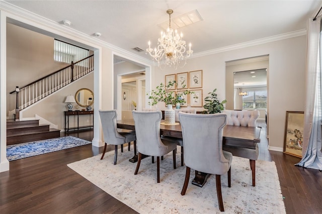 dining room featuring visible vents, crown molding, stairway, an inviting chandelier, and wood finished floors