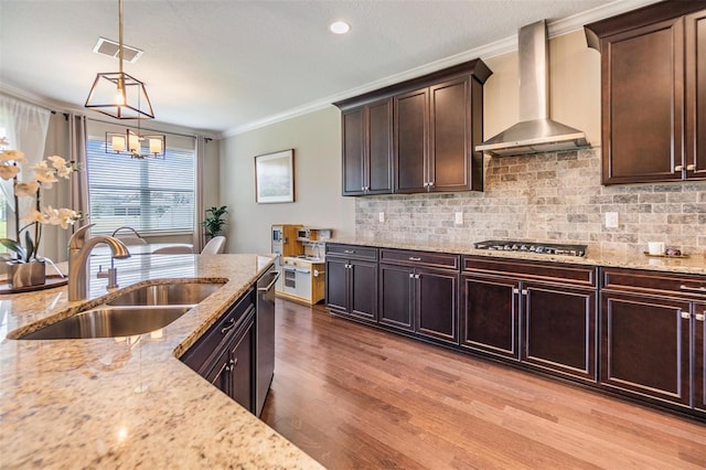 kitchen with backsplash, wall chimney range hood, ornamental molding, appliances with stainless steel finishes, and a sink