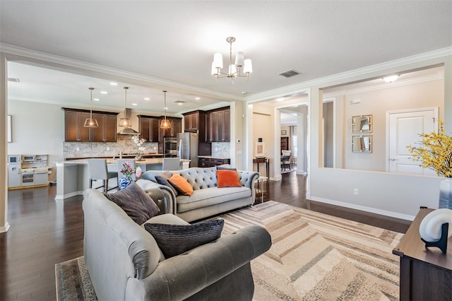 living room with visible vents, dark wood-type flooring, a notable chandelier, ornamental molding, and baseboards