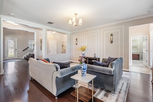 living area with visible vents, ornamental molding, stairs, an inviting chandelier, and dark wood-style flooring