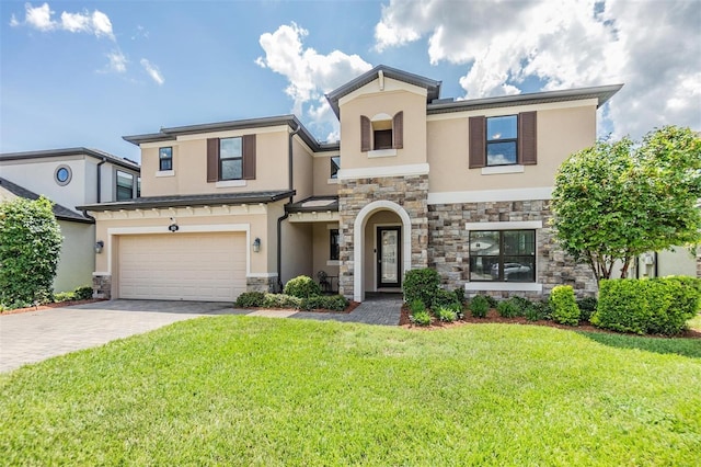 view of front of house featuring a front lawn, stucco siding, decorative driveway, stone siding, and an attached garage