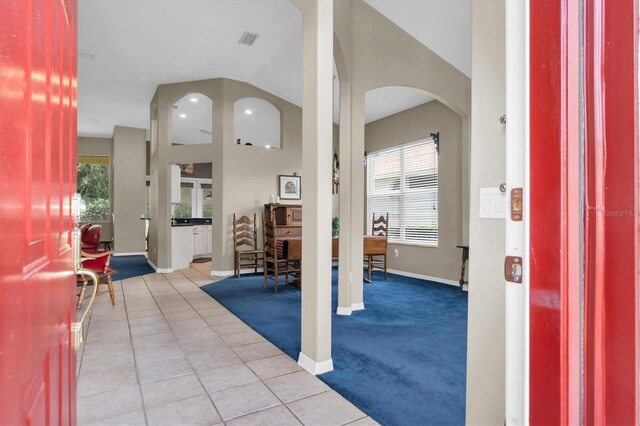 tiled foyer entrance featuring vaulted ceiling