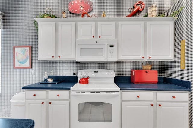 kitchen featuring white cabinetry and white appliances