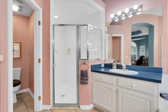 bathroom with vanity, toilet, tile patterned floors, and walk in shower