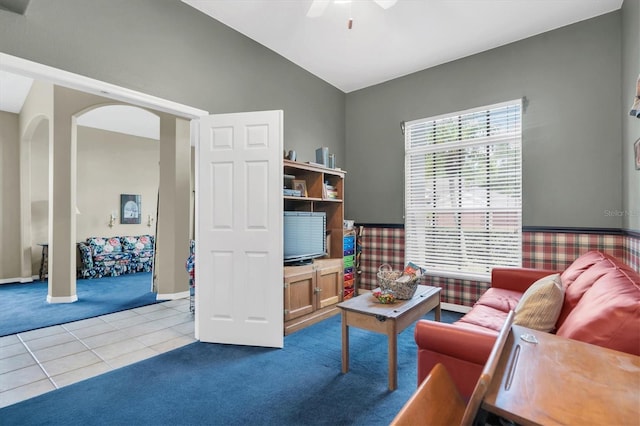 living room with light tile patterned flooring, ceiling fan, and vaulted ceiling