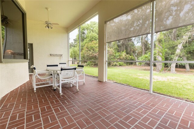 unfurnished sunroom with ceiling fan