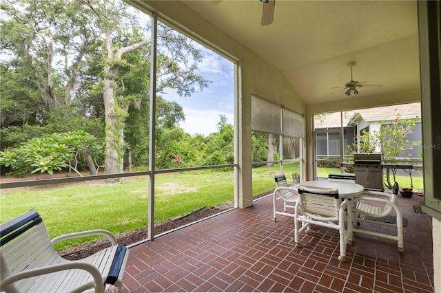 sunroom featuring ceiling fan and vaulted ceiling