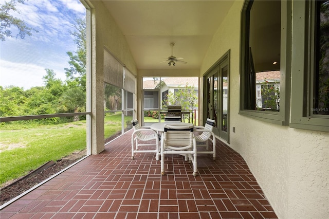 unfurnished sunroom with ceiling fan