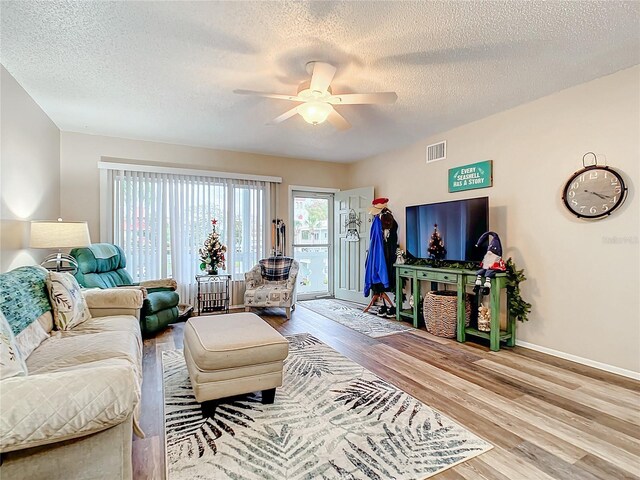 living room featuring a textured ceiling, light hardwood / wood-style flooring, and plenty of natural light