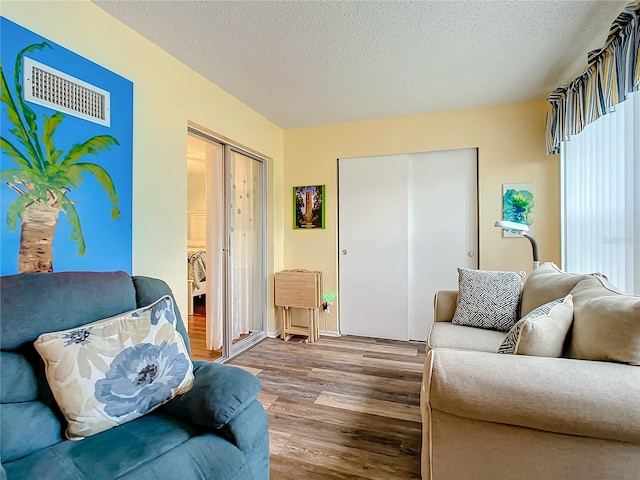 living room featuring hardwood / wood-style flooring and a textured ceiling