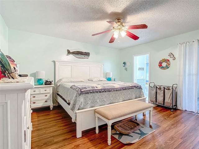 bedroom with wood-type flooring, a textured ceiling, ensuite bath, and ceiling fan